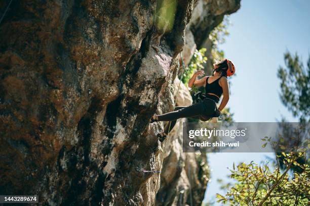 one asian young climber woman climbing on the rock - adrenaline stress stock pictures, royalty-free photos & images