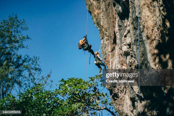 kletterer fotografiert aufsteigenden teamkollegen - kletterseil stock-fotos und bilder