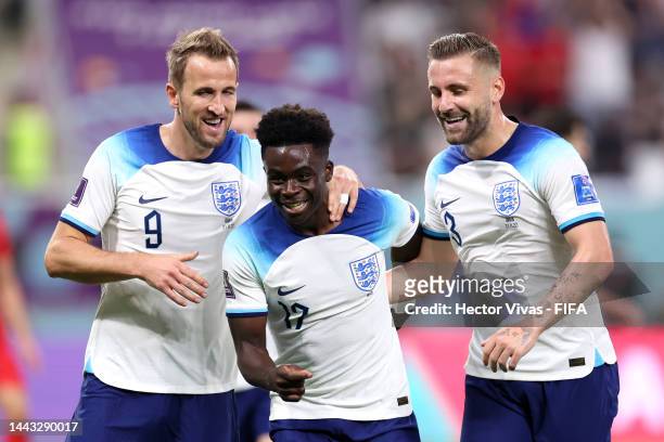 Bukayo Saka of England celebrates with Harry Kane and Luke Shaw after scoring their team's fourth goal during the FIFA World Cup Qatar 2022 Group B...