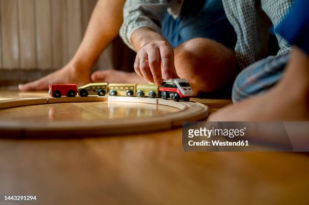 father playing with toy train on floor at home - model train stock pictures, royalty-free photos & images