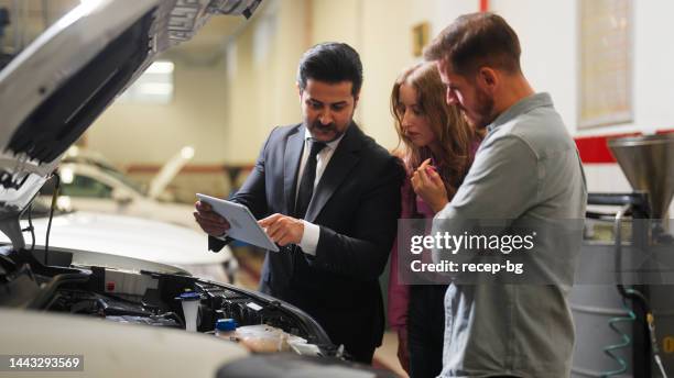 car insurance expert checking broken car and discussing with couple - choosing insurance stock pictures, royalty-free photos & images