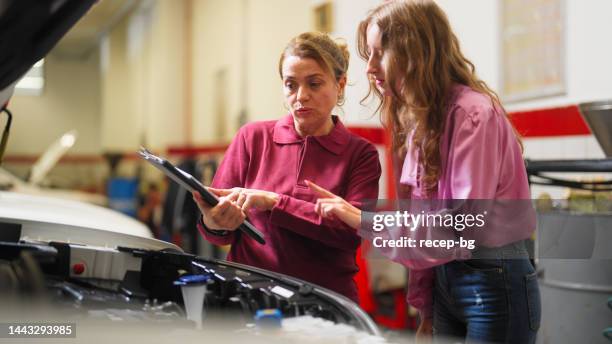 car mechanic expert checking broken car and discussing with owner - happy client by broken car stock pictures, royalty-free photos & images