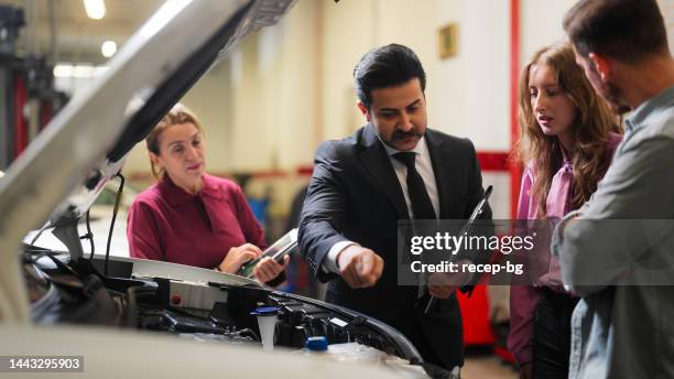 car insurance expert checking broken car and discussing with couple - happy client by broken car stock pictures, royalty-free photos & images