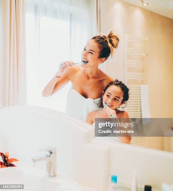 mother and daughter brushing teeth in the bathroom - hungary hotel stock pictures, royalty-free photos & images