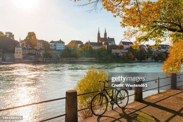 switzerland, basel-stadt, basel, bicycle on bank of rhine river - basel switzerland stock pictures, royalty-free photos & images