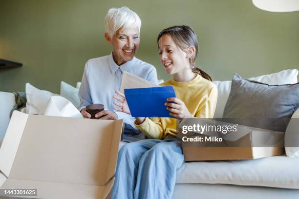 happy customers opening cardboard box with online purchase order - elderly receiving paperwork stock pictures, royalty-free photos & images