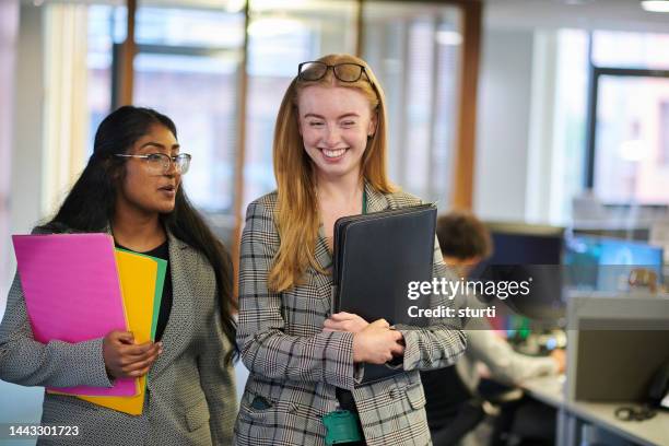 happy young paralegals walking through the office - praktikant bildbanksfoton och bilder