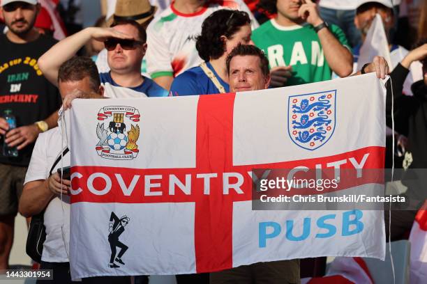 Fan holds up an St. George's cross flag bearing the Coventry City club logo during the FIFA World Cup Qatar 2022 Group B match between England and IR...