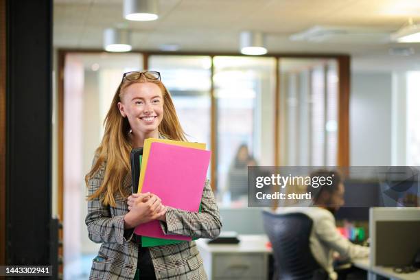 happy young paralegal walking through the office - new employee stock pictures, royalty-free photos & images