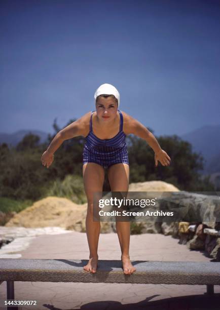 Esther Williams in swimsuit about to dive into pool, circa 1945.
