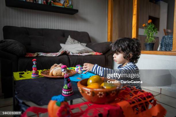 niño colocando altar de muertos - altar de muertos fotografías e imágenes de stock