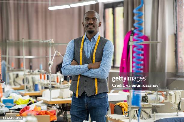 retrato de sastre afroamericano, mirando a la cámara sonriendo en el taller - sastre fotografías e imágenes de stock