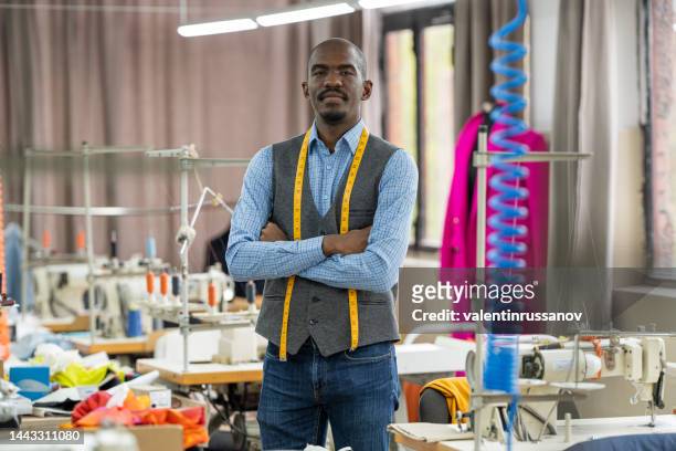 portrait of african american tailor man, looking at the camera smiling in atelier studio - tailor stock pictures, royalty-free photos & images