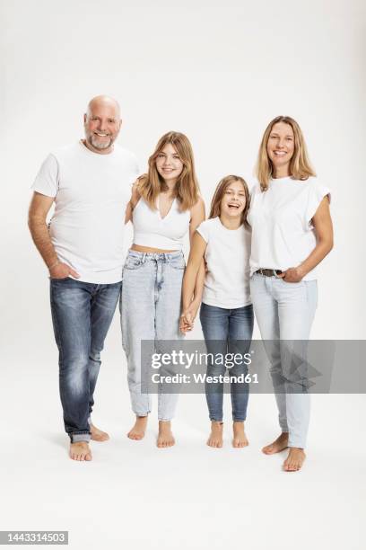 happy children laughing with parents in studio - freisteller gruppe kinder erwachsene ganzkörperansicht stock-fotos und bilder