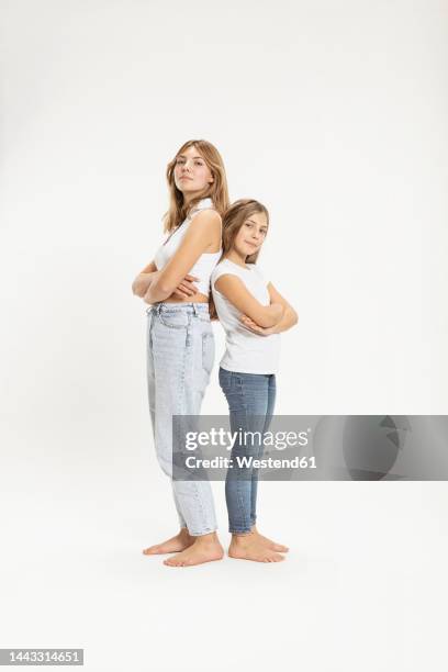 confident girls with arms crossed in studio - kids standing crossed arms stock-fotos und bilder