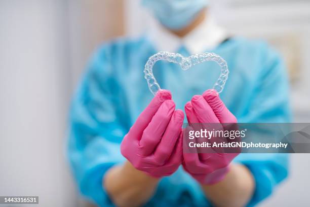 orthodontist holding denta aligners. - invisalign stock pictures, royalty-free photos & images