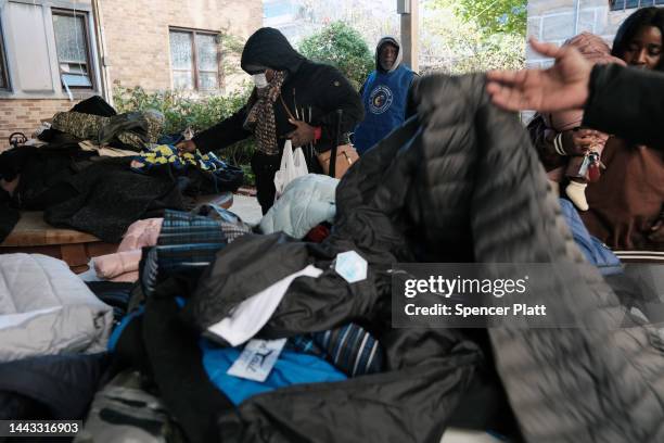 People look through free coats and jackets as they line-up to receive a free Thanksgiving turkey at the Holy Innocents Roman Catholic Church in...