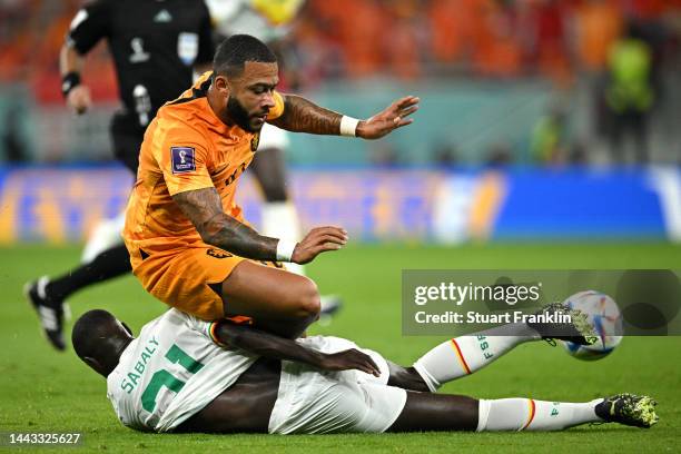 Memphis Depay of Netherlands is challenged by Youssouf Sabaly of Senegal during the FIFA World Cup Qatar 2022 Group A match between Senegal and...