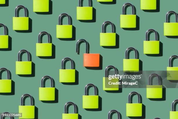 an opened lock standing out from locked locks - herhaling begrippen stockfoto's en -beelden