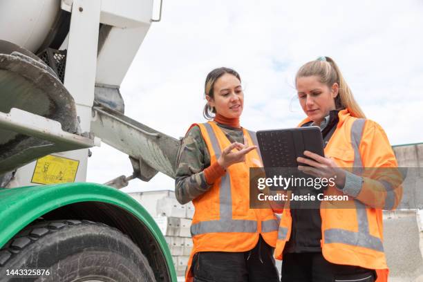 two female co workers talk together on site - siteseeing stock-fotos und bilder