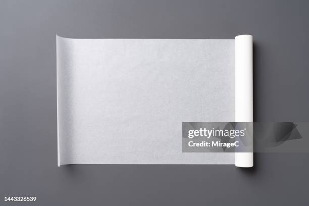 a roll of baking paper unrolled on gray - rolar imagens e fotografias de stock