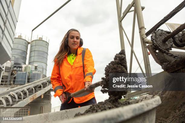 a female works at concrete manufacturing plant - betonmischmaschine stock-fotos und bilder