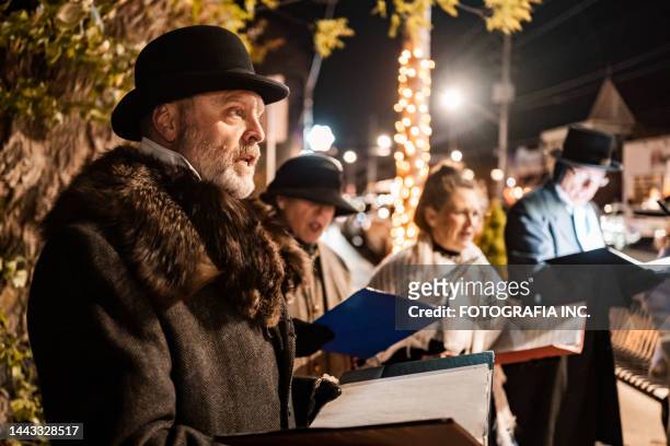 reife menschen singen nachts weihnachtslieder im freien - folk stock-fotos und bilder