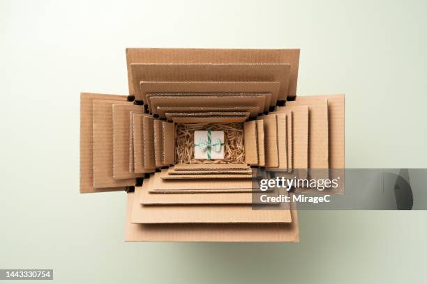 small gift packed in multiple cardboard boxes nesting, excessive packaging - excess product stock pictures, royalty-free photos & images