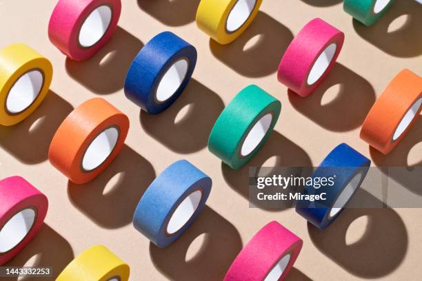 colorful adhesive tapes rolling on brown paper - organised group photo stock-fotos und bilder