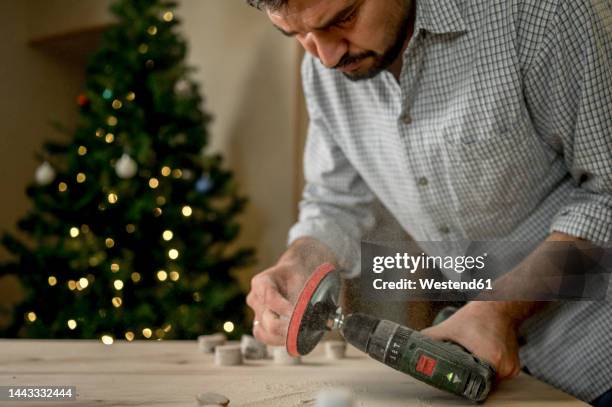 craftsman making wooden blanks through grinder at home - machine christmas tree stock pictures, royalty-free photos & images