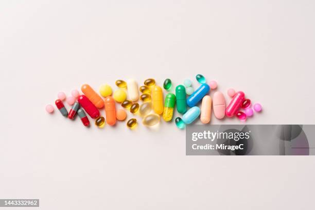 multi colored medical pills organized in a row - comprimido fotografías e imágenes de stock