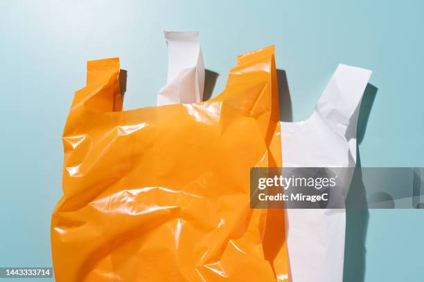 two plastic bags overlapped on blue - sac en plastique photos et images de collection