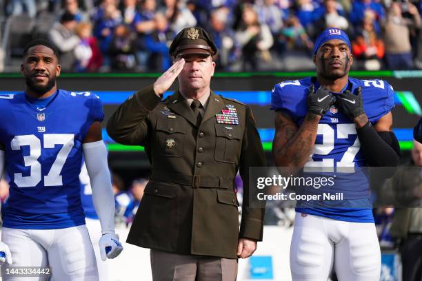 Fabian Moreau of the New York Giants stands during the national anthem with members of the armed services against the Houston Texans at MetLife...