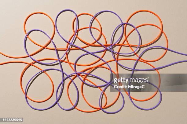 purple and orange colored strings tangled scribble - coiled wire stock pictures, royalty-free photos & images