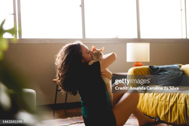 woman interacts with her pet cat - cat cuddle stockfoto's en -beelden