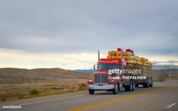 red semi transporting wood timber in utah, usa - indústria madeireira imagens e fotografias de stock