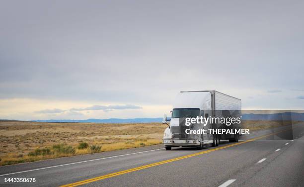 16 wheeler white semi transporting merchandising in utah, usa - schneebedeckte berge im rücken - back of truck stock-fotos und bilder