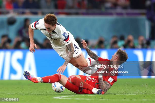 Joe Rodon of Wales tackles Josh Sargent of United States during the FIFA World Cup Qatar 2022 Group B match between USA and Wales at Ahmad Bin Ali...