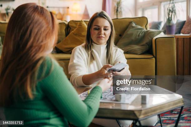 two women are playing board games at the table - tarot cards stock-fotos und bilder