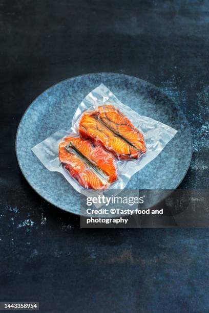 vacuum packed salmon pieces on a blue background - vacuum packed bildbanksfoton och bilder