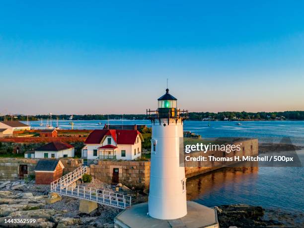 high angle view of lighthouse by sea against clear blue sky,united states,usa - new hampshire stock pictures, royalty-free photos & images