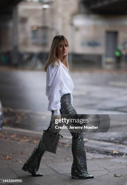 Tabea seen wearing SoSUE Antonia Short Draw String white blouse, Zara silver sparkling pants, Zara black leather boots, Prada silver shiny handbag on...