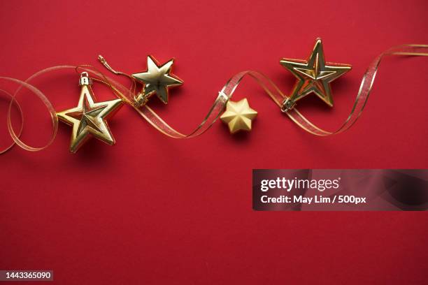 star shape christmas ornament against red background,malaysia - tree topper stock pictures, royalty-free photos & images