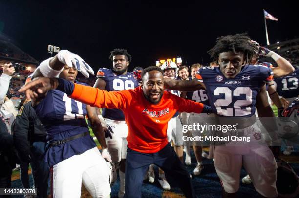 Interim head coach Carnell Williams of the Auburn Tigers celebrates with wide receiver Shedrick Jackson of the Auburn Tigers and running back Damari...