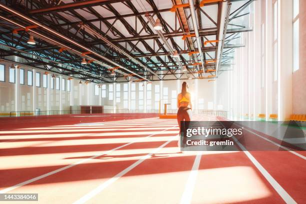 indoor running track with woman training - running track stock pictures, royalty-free photos & images