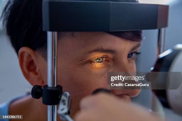 woman having an eye exam - blue eye close up stock pictures, royalty-free photos & images