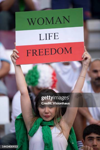 Fan holds up an Iran sign reading WOMAN LIFE FREEDOM to show solidarity with the women's protest movement in Iran during the FIFA World Cup Qatar...