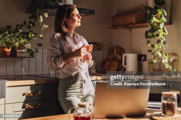 young happy woman drinking coffee on the kitchen in the morning. - casual chic stock-fotos und bilder