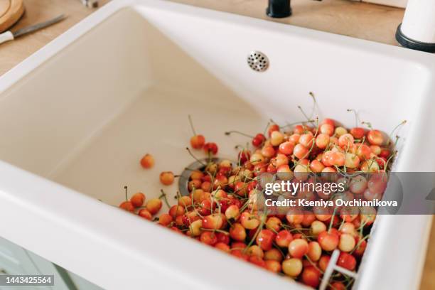 cherries in a steel sieve. top view, texture. - summer vibe stockfoto's en -beelden