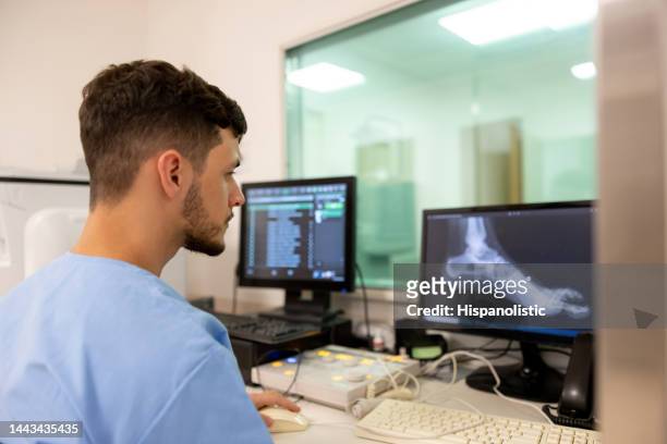 radiologe, der im krankenhaus arbeitet und eine röntgenaufnahme macht - ankle stock-fotos und bilder